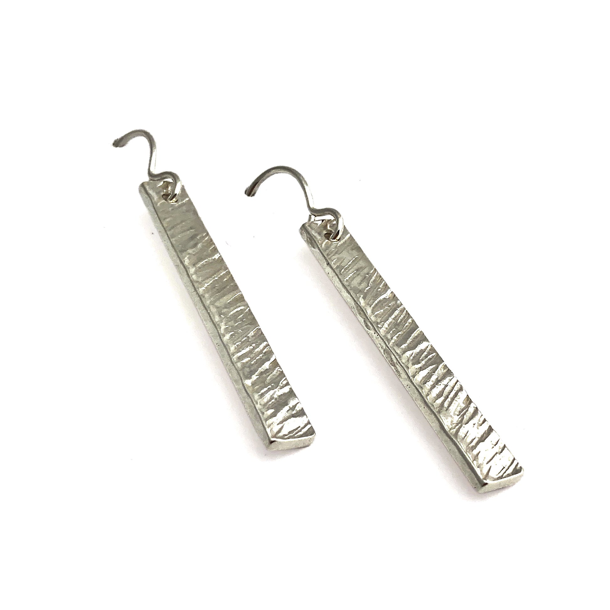Two silver vertical rectangular earrings with angled line texture laying flat