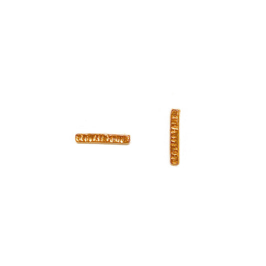 Small thin bar studs with line texture accross the short dimension photographed on a white background