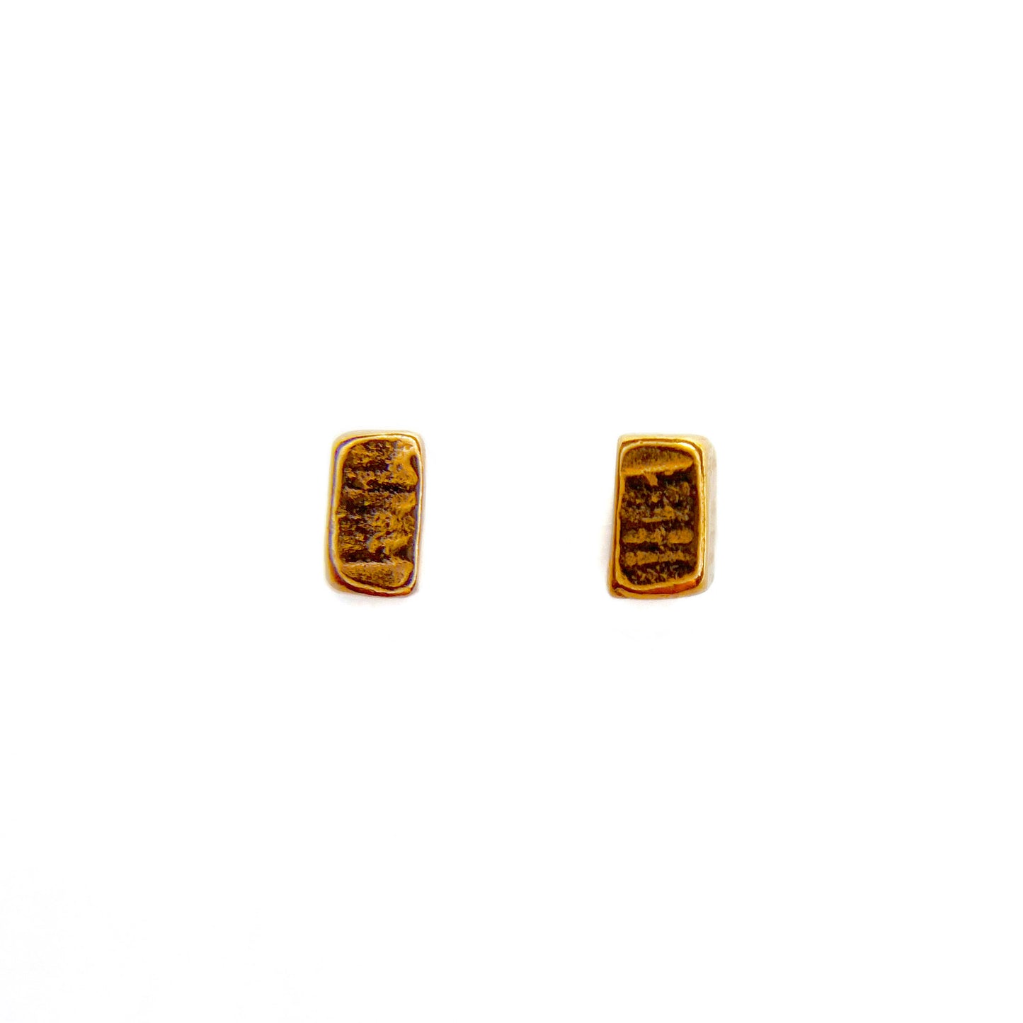 Two rose gold vermeil studs laid flat on a white background