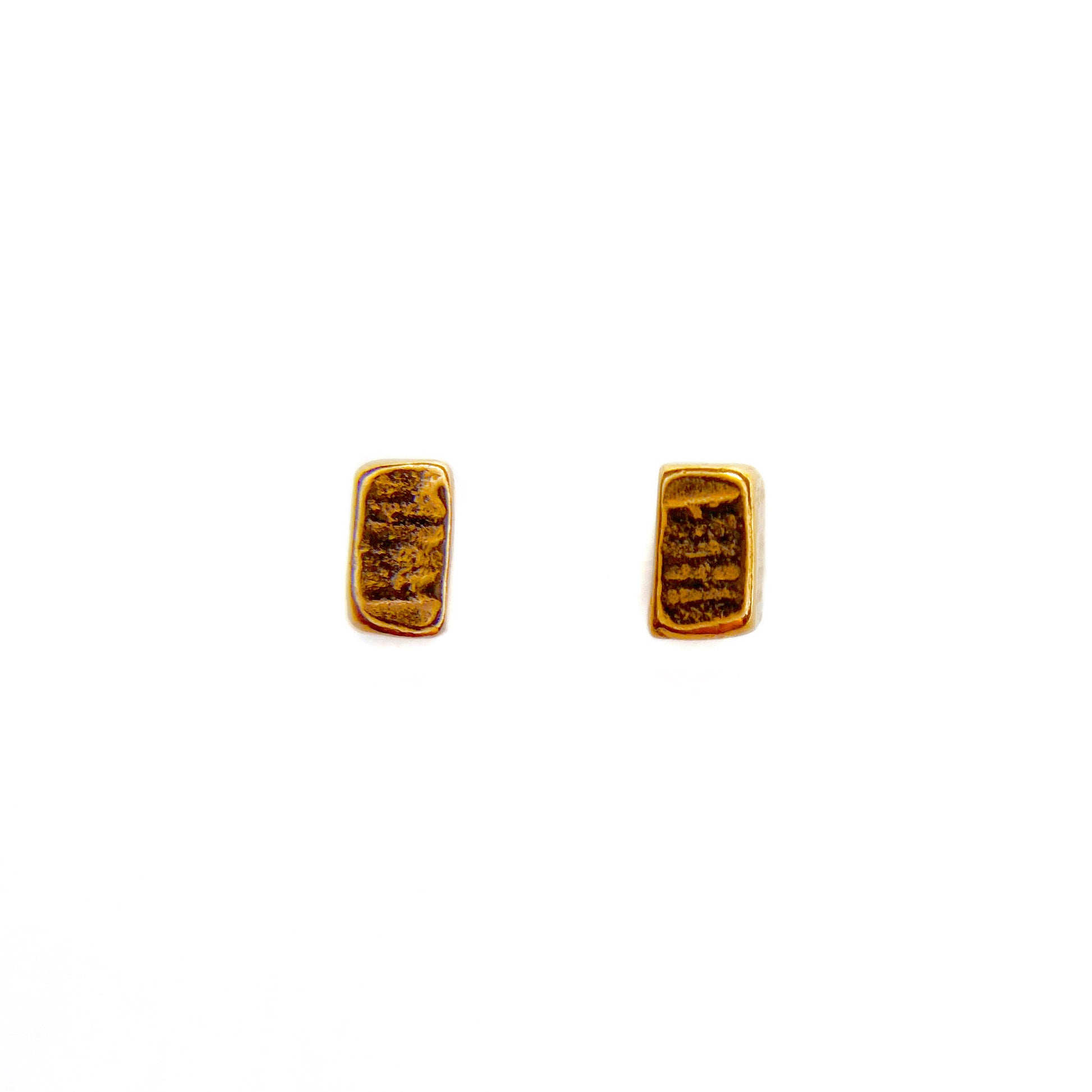 Two rose gold vermeil studs laid flat on a white background
