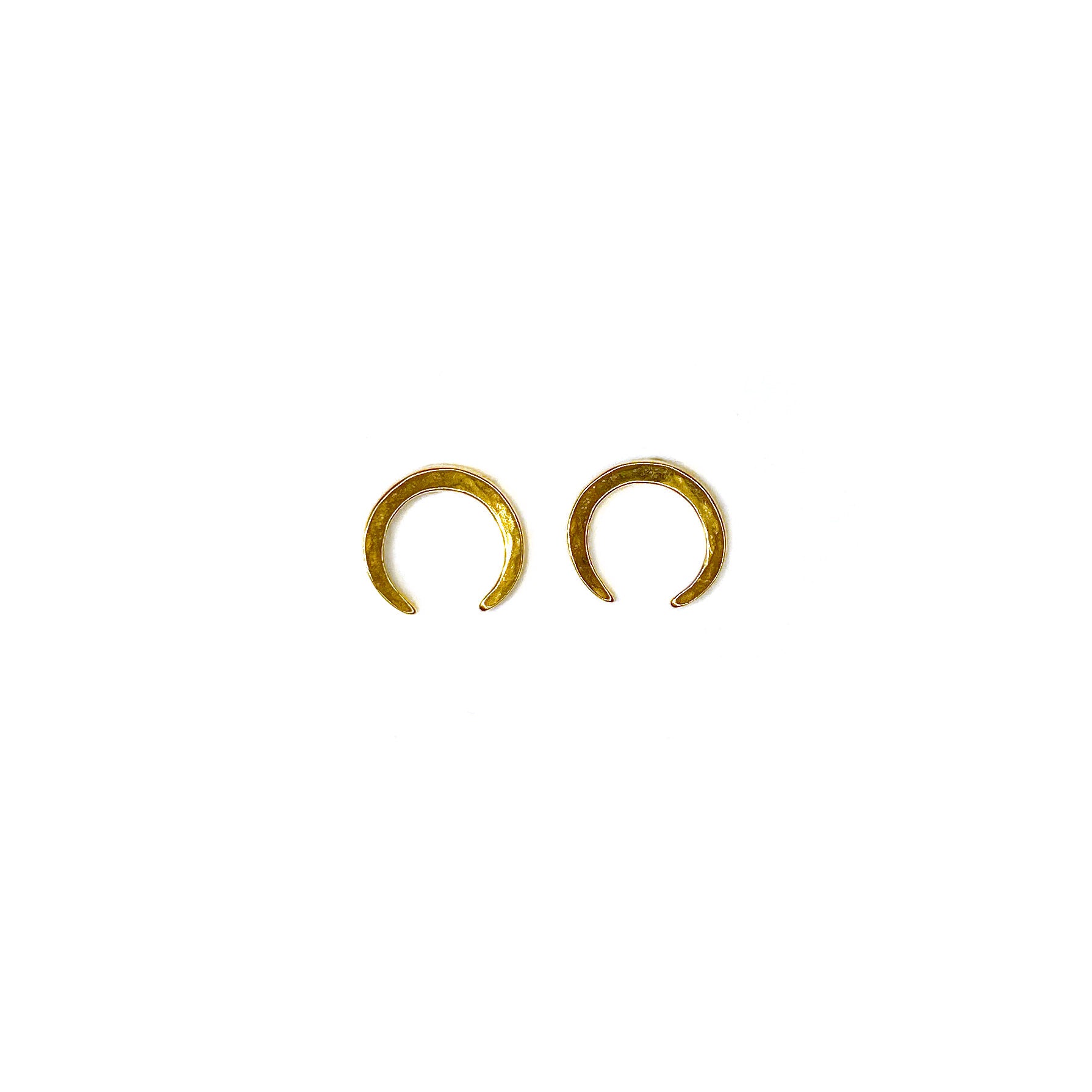 Deep crescent moon shaped hammered gold studs on a white background