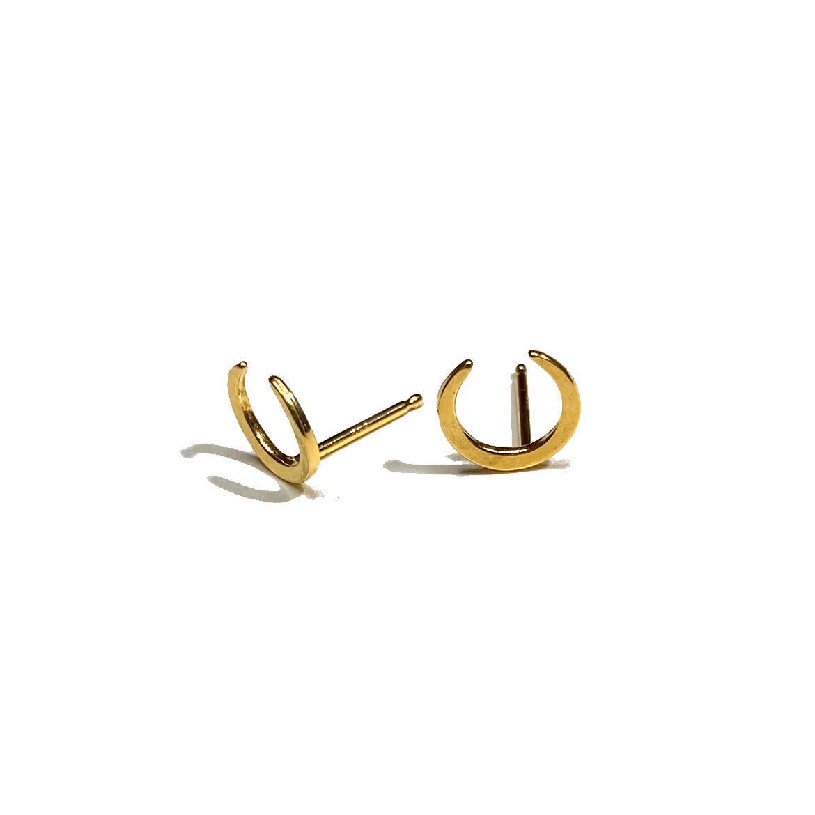 Crescent moon shaped hammered gold studs on the closed side on a white background