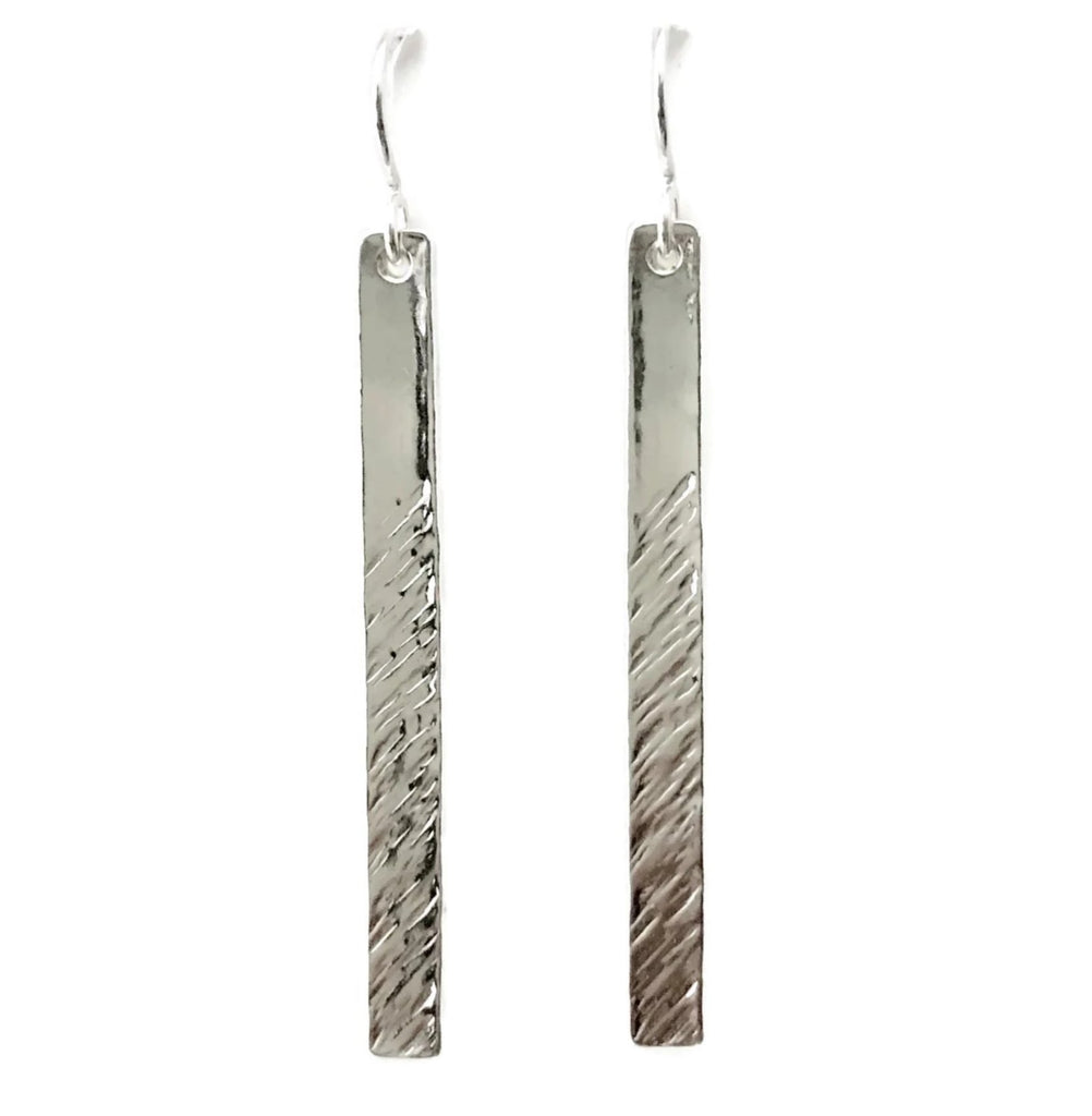 Two long silver vertical rectangular earrings with angled line texture